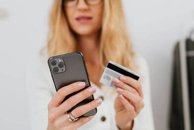 Frau mit iPhone und Kreditkarte