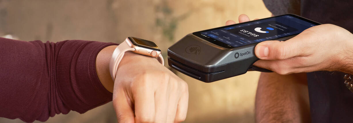 Hand mit Apple Watch am Bezahlterminal
