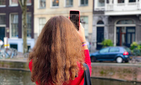 Frau nutzt Visual Intelligence auf dem iPhone in der Stadt