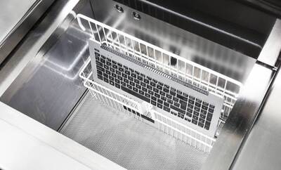 Die eingelegte Apple Tastatur zeigt das Grössenverhältnis von Techsave. Eine Apple Tastatur wird von Flüssigkeit befreit.