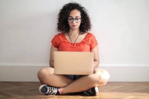 Digitale Nomadin arbeitet sitzend am Boden.