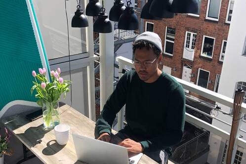 Ein digitaler Nomade arbeitet auf einer Terrasse.