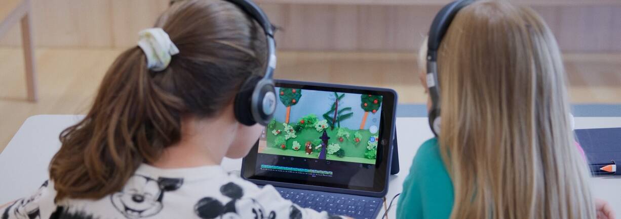 Schülerinnen mit iPad beim Coaching