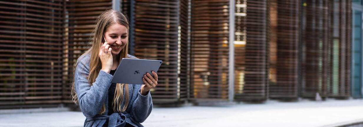 Finanzierung durch Ratenzahlung von Apple Geräten Frau mit iPad in der Hand und iPhone am Ohr