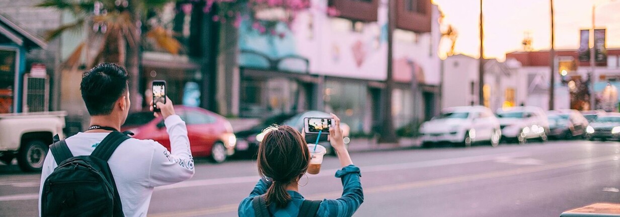Zwei Menschen fotografieren mit iPhone in der Stadt