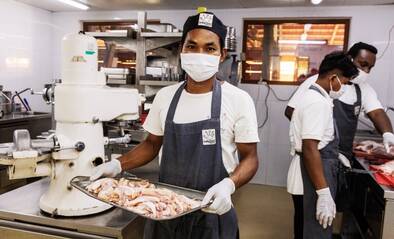 Koch mit Blech voller Essen in Kambodscha