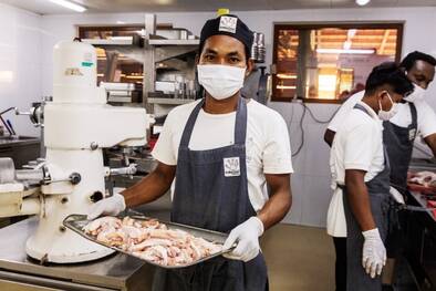 Koch mit Blech voller Essen in Kambodscha