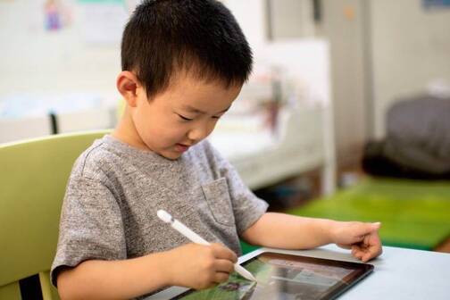 Blended Learning hilft dem Schulunterricht Junge mit iPad und Pencil in der Schule