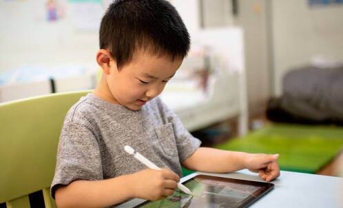 Junge mit iPad und Pencil in der Schule