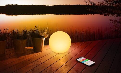 Eve Flare lässt sich tragen und dimmen Die Lampe Eve Flare auf einer Terrasse am Wasser