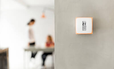 Netatmo liefert Komponenten fürs Smart Home System Raumthermostat von Netatmo an der Wand im Wohnzimmer
