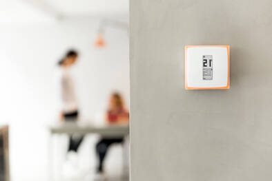 Raumthermostat von Netatmo an der Wand im Wohnzimmer