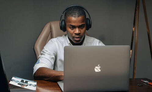 Ein Mann arbeitet daheim mit dem MacBook seines Arbeitgebers, das über MDM verwaltet wird.