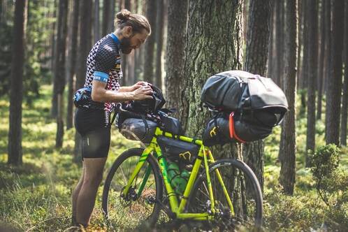 Ein Bikepacker orientiert sich auf seiner Route bei einer Pause 