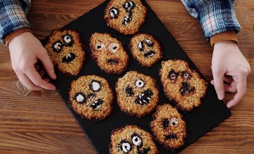 Website-Cookies werden oft durch essbare Kekse dargestellt Cookies mit Gesichtern auf einem Blech