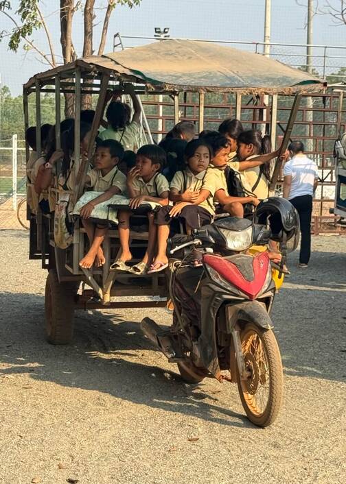 In Kambodscha werden Kinder mit einem Motorradanhänger nach Hause gefahren. Transport der Kinder in Kambodscha von der Schule nach Hause