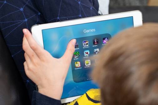 Ein Junge verwendet sein iPad fürs mobile Gaming