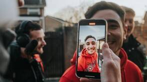 Ein junger Mann wird mit iPhone gefilmt Mit iPhone ein Video aufnehmen