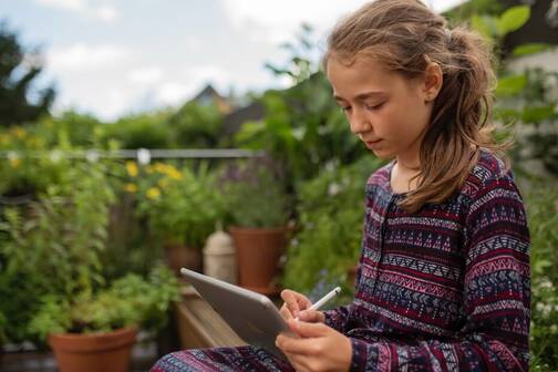 KI fürs Lernen nutzen mit Apple Intelligence Mädchen draussen mit iPad