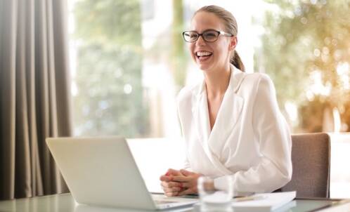 Frau in weisser Bluse arbeitet mit MacBook