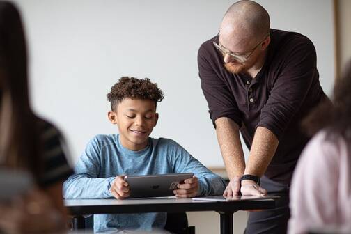 MDM-Einschränkungen in der Schule zum Schutz von Schulgeräten Lehrperson hilft Schüler mit iPad