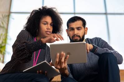 Externer IT-Service von DQ Solutions Zwei Lehrpersonen sitzen vor einem iPad