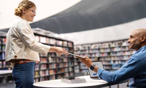 Lehrperson gibt Studentin ein iPad