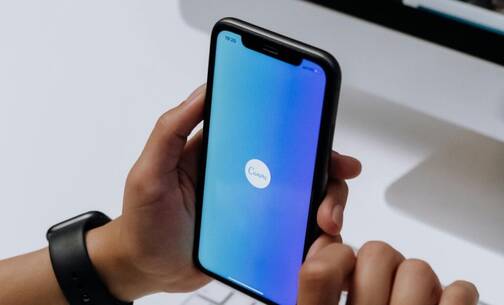 Canva – eine nützliche App für jeden Tag iPhone mit blauem Screen und Canva-App Logo
