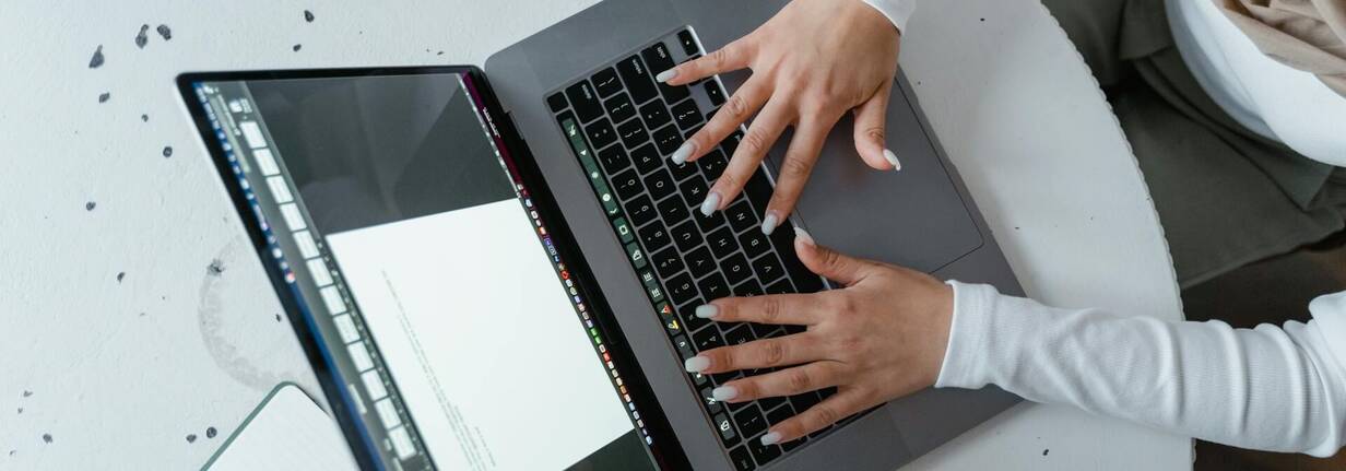 Arbeiten mit Shortcuts auf MacBook Keyboard Zwei Hände gleiten über Tastatur von MacBook