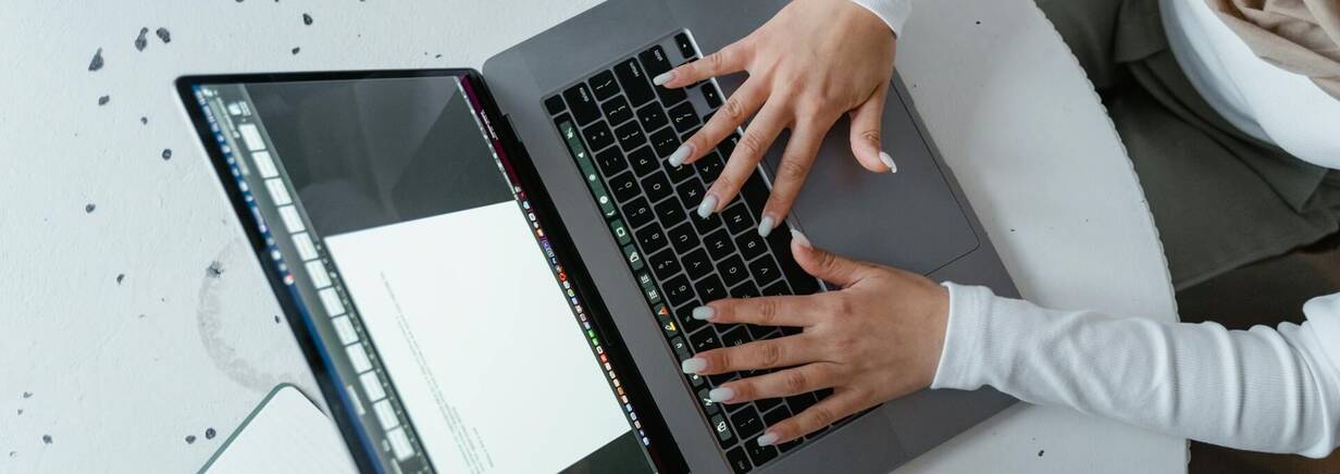 Arbeiten mit Shortcuts auf MacBook Keyboard Zwei Hände gleiten über Tastatur von MacBook