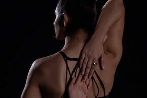 Ultrahuman Air bei einer Frau in Sport-Outfit an der Hand Frau dehnt Arme hinter dem Rücken mit Ultrahuman Ring an der Hand