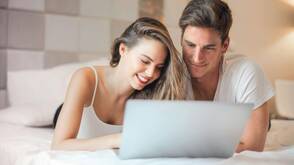 Unterhaltung durch Streaming-Dienste (Foto: Olly / pexels) Ein Paar liegt auf dem Bett und wählt einen Film auf dem Mac