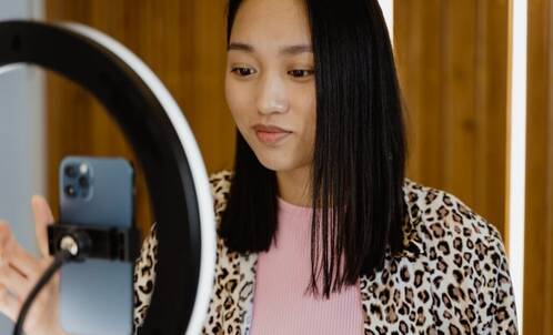 junge Frau nimmt Video auf mit iPhone in Ringlicht