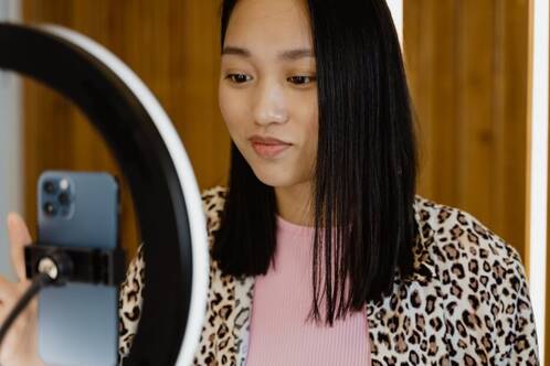 junge Frau nimmt Video auf mit iPhone in Ringlicht