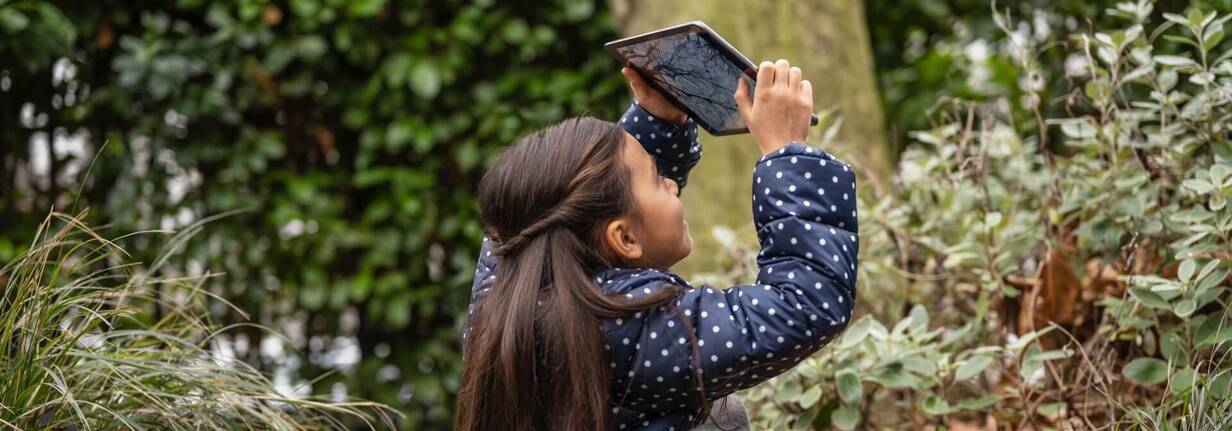 Mädchen in der Natur nimmt Foto mit iPad auf (Foto: Apple) Schülerin nimmt Foto von Baumkrone auf