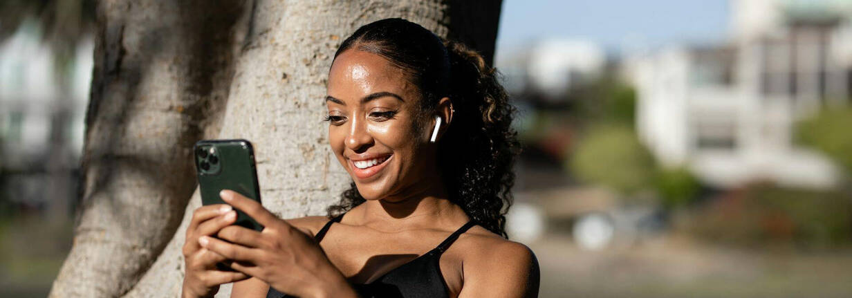 Reinigung des viel benutzten iPhone ist wichtig (Foto: Ketut Subiyanto / pexels) sportliche Frau im Park mit iPhone