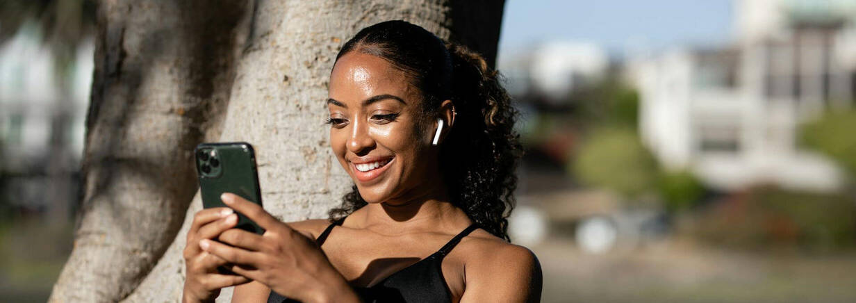 Reinigung des viel benutzten iPhone ist wichtig (Foto: Ketut Subiyanto / pexels) sportliche Frau im Park mit iPhone