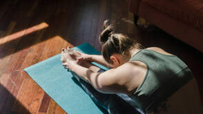 Stretching zu Hause auf der Matte (Foto: Tim Samuel / pexels) Frau beim Stretching auf Yogamatte