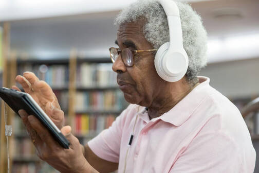 älterer Mann tippt etwas auf iPad (Foto: Kampus / pexels) Senior mit AirPods Max und iPad