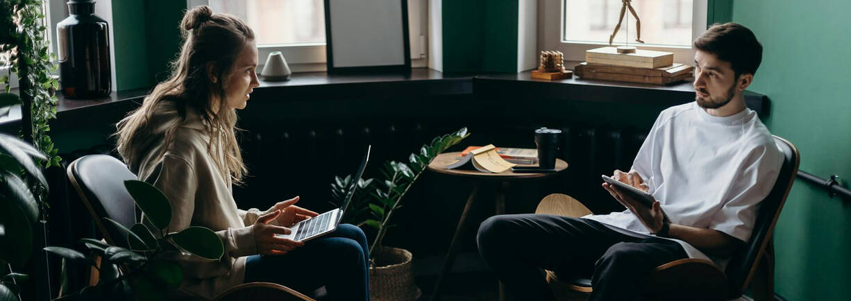 Zwei Apple User sitzen sich gegenüber