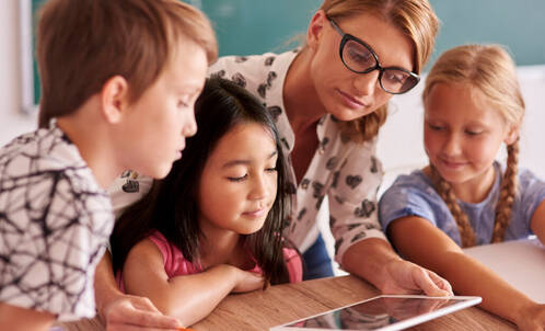 Lehrperson mit Lernenden und iPad