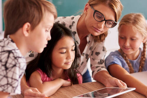 Lehrperson mit Lernenden und iPad