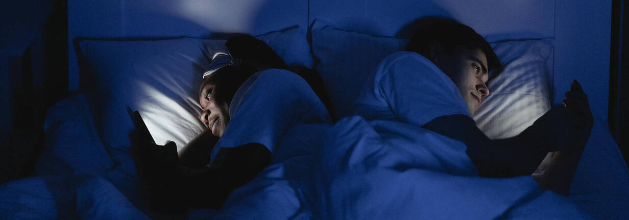 Paar im Bett mit iPhone 