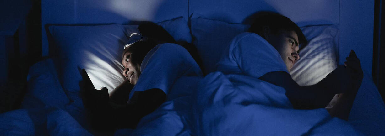 Paar im Bett mit iPhone 