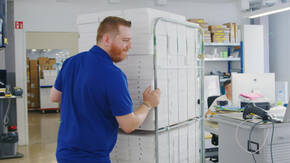 Mitarbeiter von DQ Solutions mit einem Stapel iPad