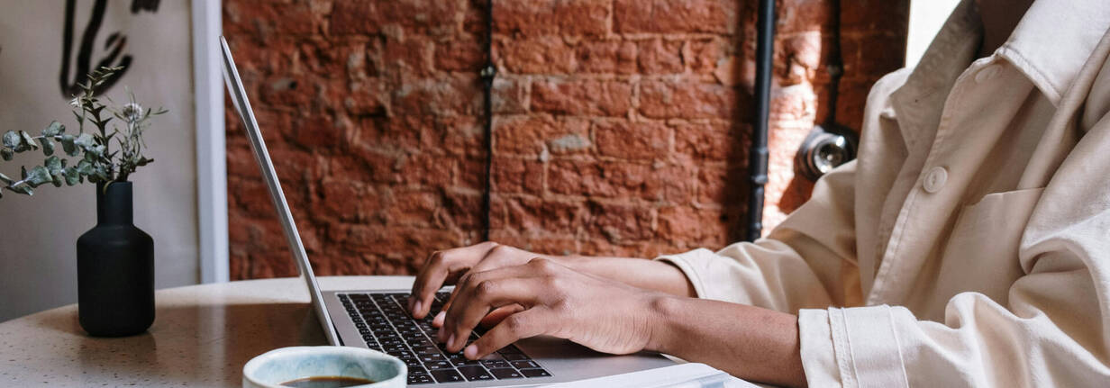 Person mit MacBook - Kopf ausserhalb des Bildes