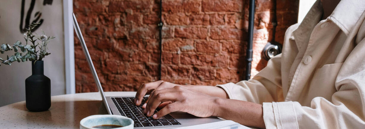 Person mit MacBook - Kopf ausserhalb des Bildes