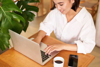 Frau mit MacBook und Kaffee