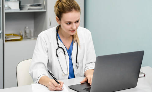 Ärztin arbeitet am MacBook