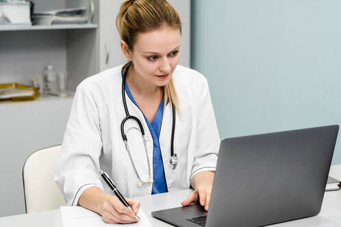 Ärztin arbeitet am MacBook